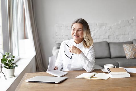Cheerful,Middle,Aged,Woman,Smiling,Broadly,,Enjoying,Reading,Good,Book